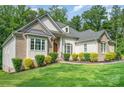 Elegant home showcasing detailed brickwork, multiple windows, and vibrant landscaping, set against a backdrop of mature trees at 10874 Rise Ln, Fort Mill, SC 29707