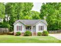 Charming single-story home with well-manicured lawn, covered front porch, and lush green trees at 110 Eighth St, York, SC 29745