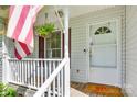 Close-up of the cozy front porch with American flag and hanging flower basket at 110 Eighth St, York, SC 29745