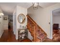 Hallway with wood flooring, stairway with red-patterned carpet, and a round mirror hanging on the wall at 112 Ocean Dr, Shelby, NC 28152