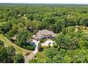 Expansive aerial view of a luxury home surrounded by lush greenery and a circular driveway at 1405 Saratoga Woods Dr, Waxhaw, NC 28173