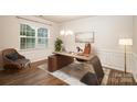 Bright home office features a modern desk, chair, hardwood floors, large window, and stylish decor at 150 W Morehouse Ave, Mooresville, NC 28117