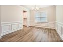 Dining room featuring wainscoting, hardwood floors, and a modern chandelier at 1540 Croydon St, Indian Land, SC 29707