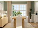 Bright dining room with a wooden table, white upholstered chairs, and a large window at 1540 Croydon St, Indian Land, SC 29707