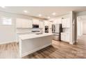 Modern kitchen with stainless steel appliances, white cabinets, an island, and hardwood floors at 1540 Croydon St, Indian Land, SC 29707
