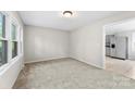 Bright, neutral living room featuring plush carpeting and ample natural light from a large window at 1606 Northwoods Dr, Kings Mountain, NC 28086