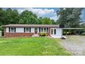 Ranch-style home with a brick facade, well-kept lawn, and convenient covered parking at 1691 Hill River Rd, Hiddenite, NC 28636