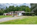 Well-kept home with front lawn, convenient parking, and outdoor storage space at 1691 Hill River Rd, Hiddenite, NC 28636