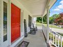 Cozy front porch featuring a vibrant red door and classic rocking chairs at 185 Eastcliff Se Dr, Concord, NC 28025