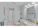Renovated bathroom with granite countertop, framed mirror, updated lighting, and tile floors at 3308 Selwyn Farms Ln # 5, Charlotte, NC 28209