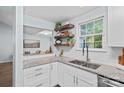 Beautiful kitchen boasts granite countertops, white cabinets, and floating shelves at 3308 Selwyn Farms Ln # 5, Charlotte, NC 28209