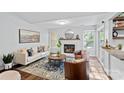 Cozy living room features a fireplace, plush seating, wood flooring, and natural light from the windows at 3308 Selwyn Farms Ln # 5, Charlotte, NC 28209