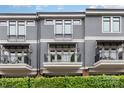 Three-story gray townhome with balconies, black railings, and lush green hedge at 428 E 33Rd St, Charlotte, NC 28205