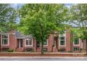 Three red brick townhomes featuring black-framed windows and beautifully landscaped front yards at 428 E 33Rd St, Charlotte, NC 28205