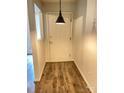 Welcoming hallway with wood-look floors and a modern pendant light fixture at 4317 Waxhaw Indian Trail Rd, Indian Trail, NC 28079
