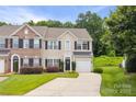 Traditional style home with brick and tan siding, black shutters, manicured landscaping, and a driveway at 444 Battery Cir, Clover, SC 29710