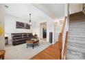 Cozy living room with a leather sofa, chandelier, and staircase leading to the upper level at 444 Battery Cir, Clover, SC 29710