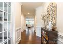 Inviting hallway with dark hardwood floors, light walls and decor with entry to a living room at 5130 Watersail Way, Clover, SC 29710