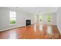 Spacious living room with a fireplace, hardwood floors, and large windows offering natural light at 6033 Edinmeadow Ln, Charlotte, NC 28269