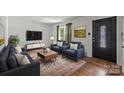 Modern living room featuring hardwood floors, neutral walls, and stylish furnishings at 6231 Coach Hill Ln, Charlotte, NC 28212