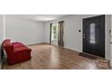 Bright living room with hardwood floors and a large front door at 6231 Coach Hill Ln, Charlotte, NC 28212