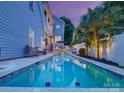 A stunning pool with cascading waterfall surrounded by lush landscaping and an outdoor seating area at 628 Bracket St, Fort Mill, SC 29708