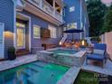 An outdoor oasis with a spa, waterfall feature, and cozy seating area with a view of the home at 628 Bracket St, Fort Mill, SC 29708