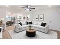 Bright living room featuring a modern sectional sofa, wood floors, and ceiling fan at 818 Stowe Ln, Gastonia, NC 28056