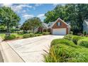 Well-maintained brick home featuring a spacious driveway and lush front yard landscaping at 9419 Olivia Ln, Charlotte, NC 28277