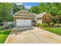 Charming home with a stone and siding exterior, attached garage, and long driveway at 1009 Jerry Ln, Matthews, NC 28105