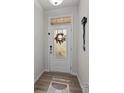 Bright entryway featuring a decorative glass door, coat hooks, and wood-look flooring at 12205 Gambrell Dr, Charlotte, NC 28278