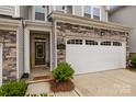 Inviting townhome featuring a welcoming front door, stone accents, and attached garage at 12205 Gambrell Dr, Charlotte, NC 28278