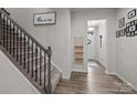 Hallway featuring a staircase, wood-look flooring, and a view of the front door at 12205 Gambrell Dr, Charlotte, NC 28278
