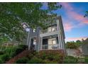 Beautiful two-story home with a covered porch and charming architectural details at sunset at 14034 Holly Springs Dr, Huntersville, NC 28078