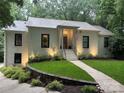 Elegant white brick home with a well-lit front entrance, and mature landscaping at 1408 Rinehart Ct, Charlotte, NC 28270
