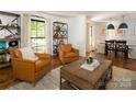 Open-concept living room with hardwood floors, large windows, and stylish furnishings at 1408 Rinehart Ct, Charlotte, NC 28270