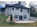 Back exterior with a patio, lush greenery, and white brick at 1427 Kinks Ln # 47, Maiden, NC 28650
