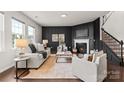 Cozy living room with a fireplace, dark accent wall, and comfortable seating, perfect for relaxing at 14407 Cardwell Hill Ln, Charlotte, NC 28278