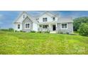 Inviting two-story home featuring a stone and white exterior, front porch, and beautiful lawn at 164 Vance Farm Dr, Statesville, NC 28625