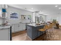 Bright eat-in kitchen featuring white cabinets, stainless appliances, marble countertops, and hardwood floors at 1922 Thomas Ave, Charlotte, NC 28205