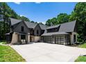 Striking home exterior with a three-car garage, stone accents, and a spacious driveway for easy access at 20000 Schooner Dr, Cornelius, NC 28031