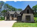 Beautiful home exterior showcasing a mix of stone and siding, complemented by lush landscaping and a manicured lawn at 20000 Schooner Dr, Cornelius, NC 28031