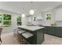 Modern kitchen with a large center island, quartz countertops, stylish stools, and stainless steel appliances at 2033 Camp Greene St, Charlotte, NC 28208