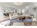 Bright living room featuring an open floor plan with hardwood floors, modern lighting, and a stylish area rug at 2033 Camp Greene St, Charlotte, NC 28208
