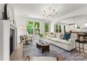 Inviting living room with a cozy fireplace, large windows, and seamless flow to the kitchen and outdoor deck at 2033 Camp Greene St, Charlotte, NC 28208
