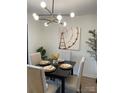 Elegant dining area with a modern chandelier, a black table set for four, and stylish decor at 2324 Brookview Ct, Rock Hill, SC 29732