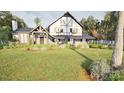 Inviting Tudor-style home with stone detailing and a picturesque landscaped front lawn and garden at 2413 Cross Country Rd, Charlotte, NC 28270
