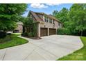 Spacious driveway leading to a three-car garage, surrounded by greenery and landscaping at 4133 Hoffmeister Dr, Waxhaw, NC 28173