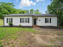 Attractive exterior showcasing a freshly painted white brick home with black shutters and tidy landscaping at 419 Wade St, Wadesboro, NC 28170