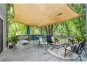 Spacious back deck with comfortable seating under a canvas shade, perfect for outdoor relaxation at 4236 Carrington Sw Ct, Concord, NC 28027